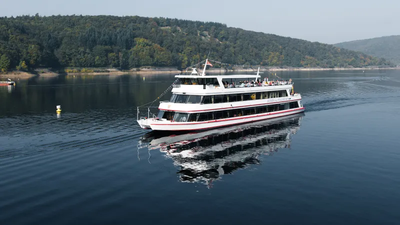 Ausflugsschiff auf dem Edersee vor bewaldeten Hügeln