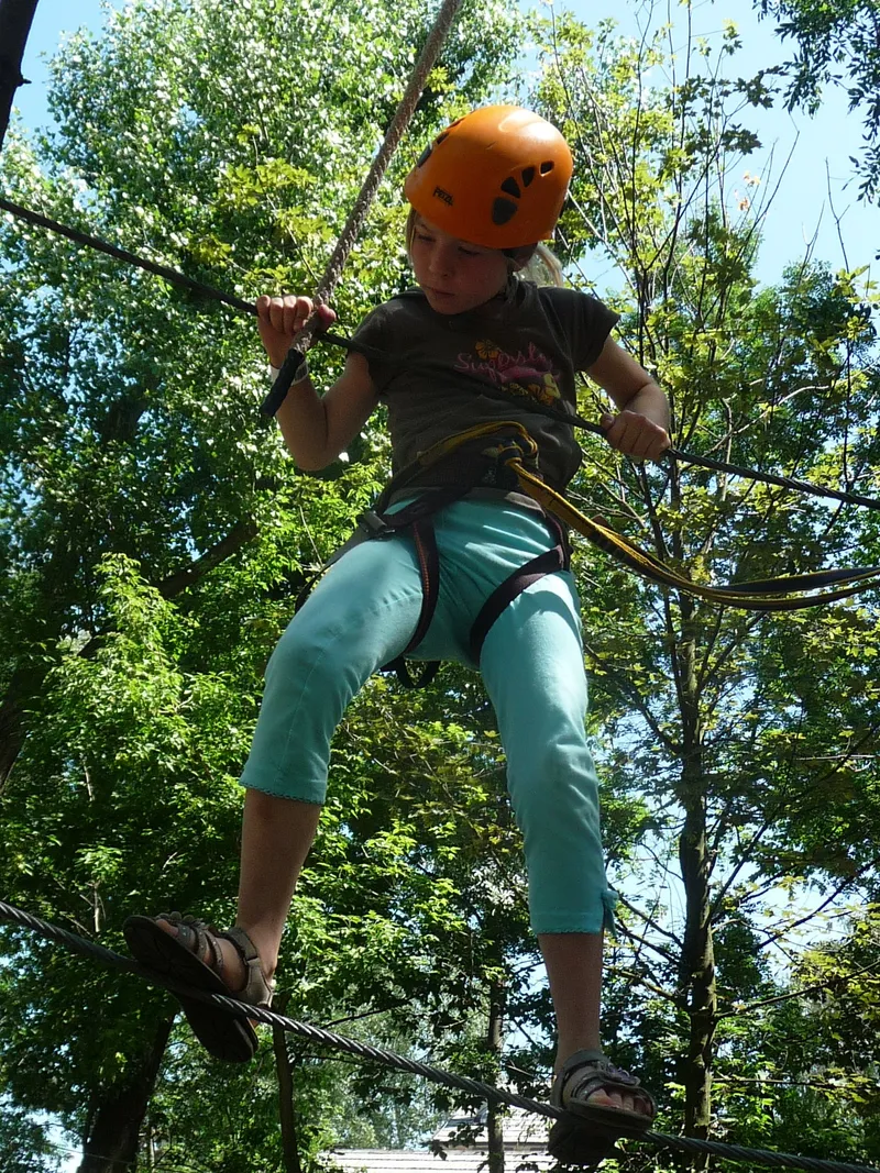 Kind im Kletterwald am Edersee, gesichert mit Helm und Klettergurt