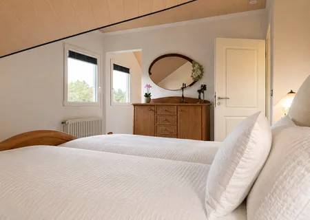 Helles Schlafzimmer der Ferienwohnung Am Wäldchen mit Doppelbett